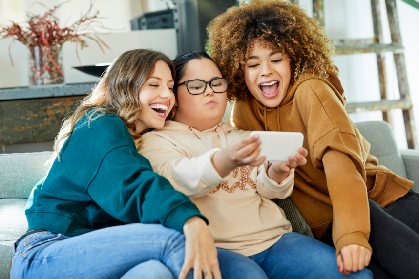 woman taking selfie with friends on sofa